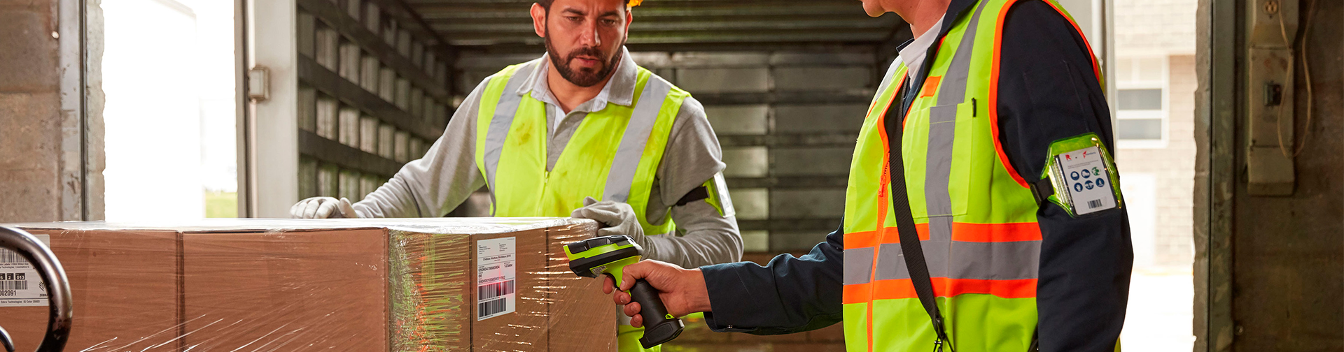 a man in a safety vest scanning a box