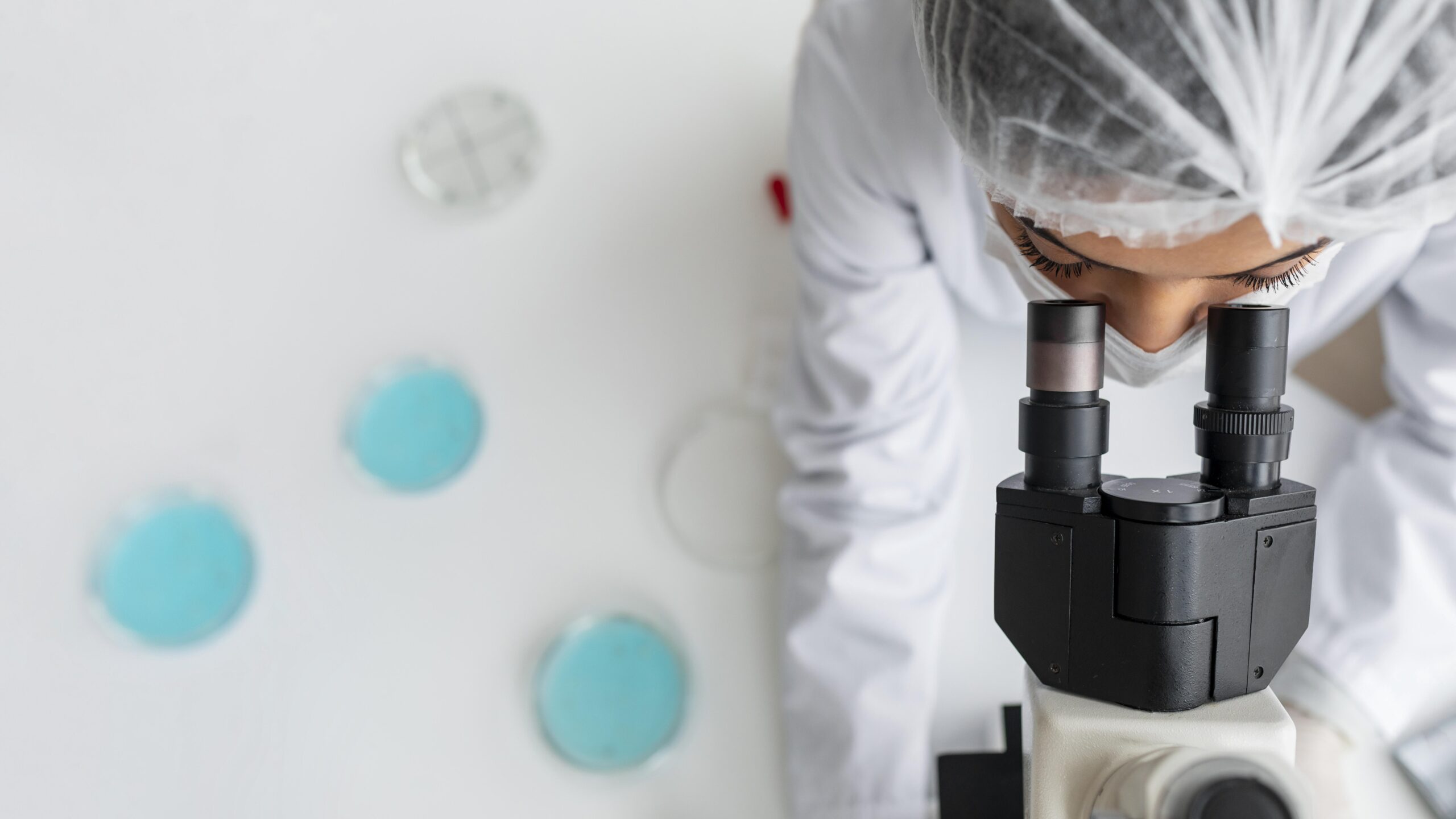 Professionnel de santé de chez BioMérieux qui étudie quelque chose dans un microscope.