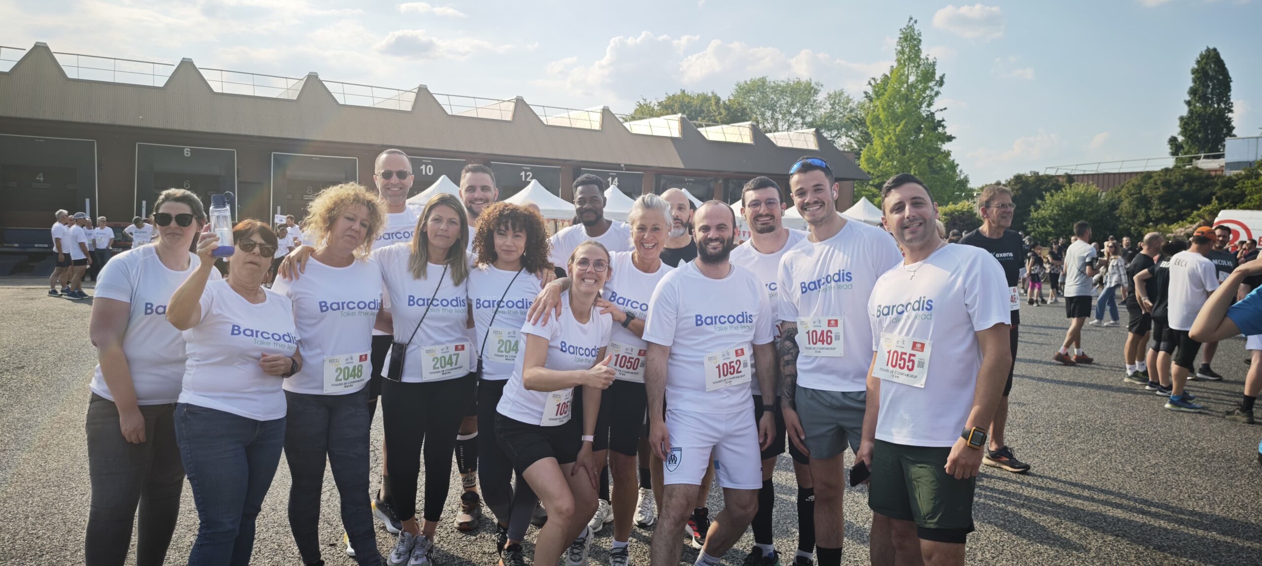 Collaborateurs de Barcodis en t-shirts blancs posant ensemble avant une course solidaire