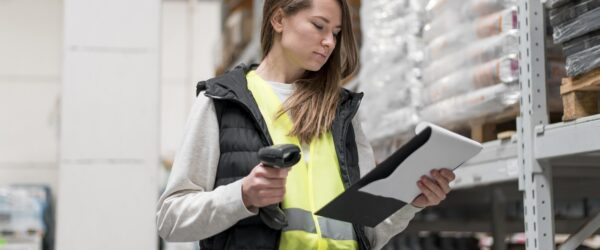 a woman holding a barcode scanner and a clipboard